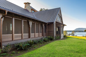 screened porch addition overlooking body of water sitting next to green grass