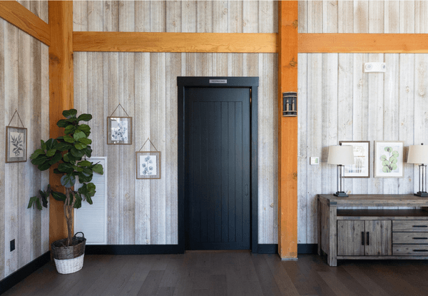 black painted custom interior door sitting beneath wood beam next to small desk